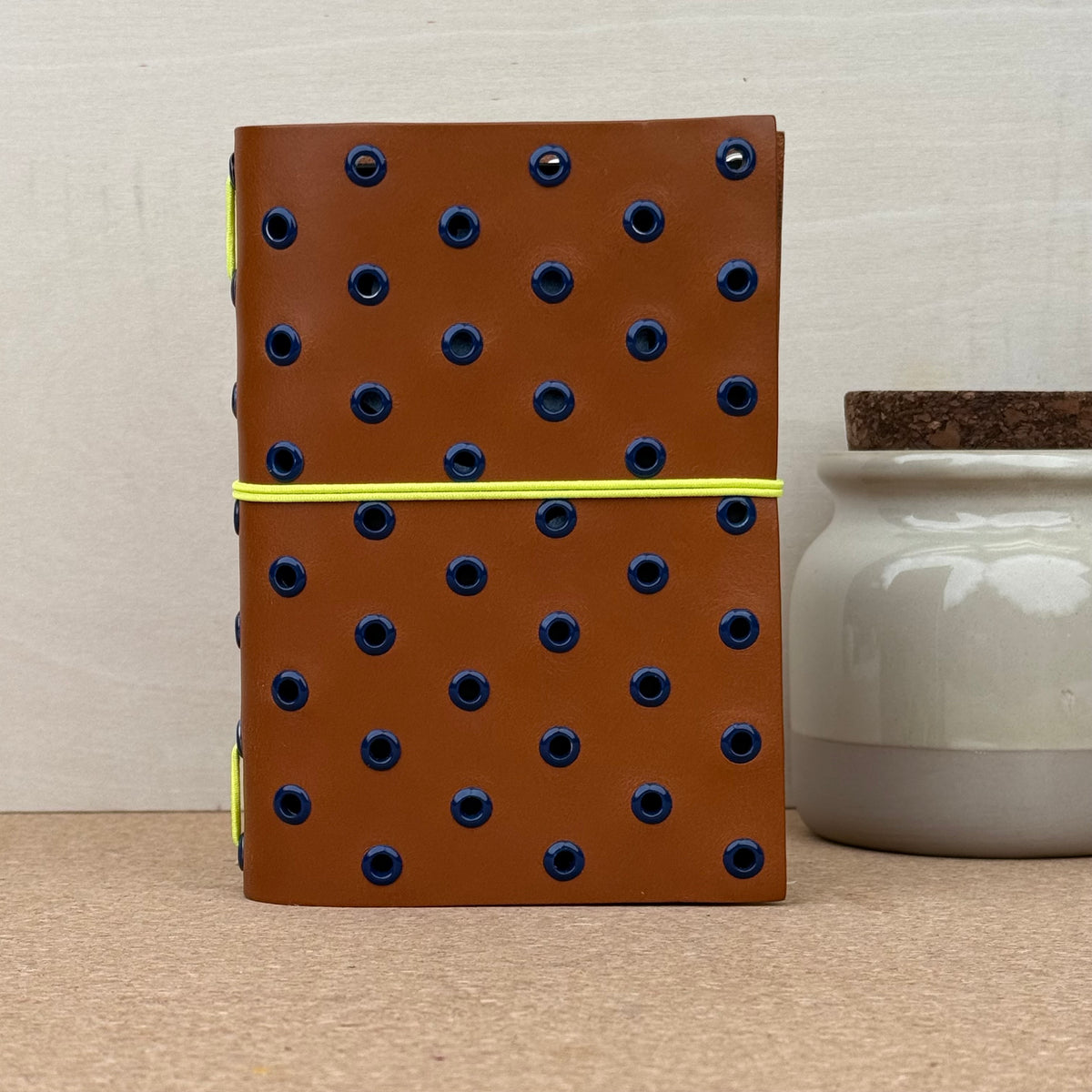 Imperfect Concepts Max Notebook - A6 Bifold - Cognac w/ Dark Blue Grommets