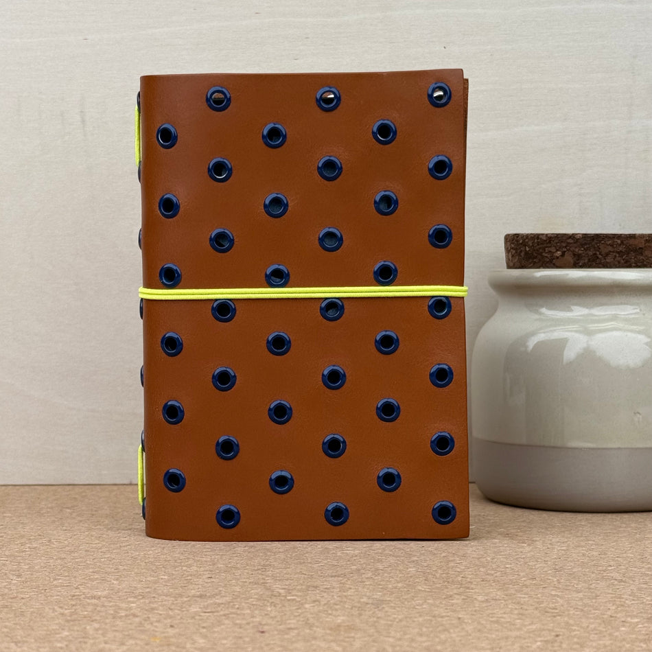 Imperfect Concepts Max Notebook - A6 Bifold - Cognac w/ Dark Blue Grommets